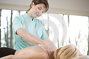 Young physiotherapist massaging