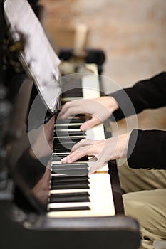 Young pianist hands with piano keys and sheet music