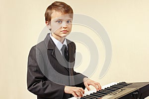 Young pianist in suit playing the digital piano