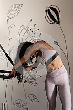 Young Pilates Instructor Woman Exercising on Pilates Reformer. Using a pilates ring