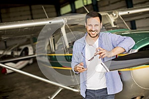 Young pilot checking ultralight airplane before flight