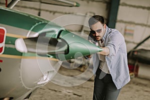 Young pilot checking ultralight airplane before flight