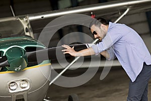 Young pilot checking ultralight airplane before flight