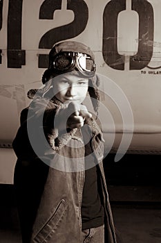 Young Pilot with flight goggles pointing at camera
