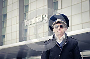 Young pilot in Kastrup airport against terminal th