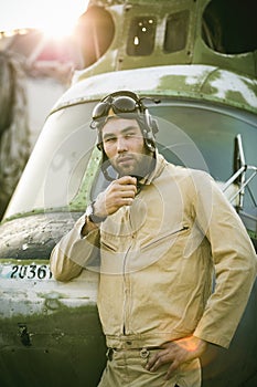 Young pilot posing near the helicopter