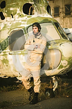 Young pilot posing near the helicopter