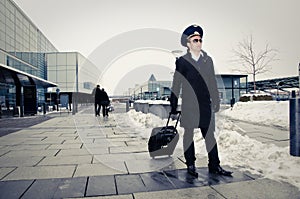 Young pilot walking with baggage in Kastrup airpor