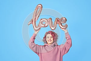 Young pink hair girl holding balloon in hands