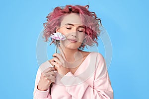 Young pink hair woman holding carnation flower