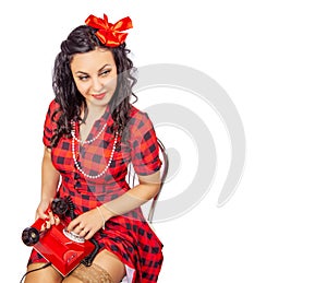 Young pinup woman sitting on a chair and calling on phone