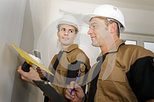 Young plasterer with manager