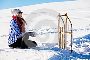 Young playful couple having fun sledging down snow covered hill