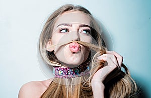 Young playful girl making moustache with her hair. Flirting dating, romantic woman and seduction girl. Beauty girl