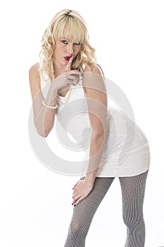 Young Playful Woman in Short Tight Mini Dress with Finger on Lip