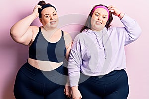 Young plus size twins wearing sportswear confuse and wonder about question