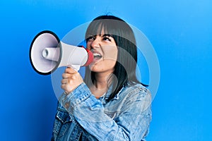 Young plus size woman shouting using megaphone