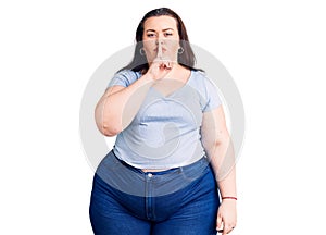 Young plus size woman wearing casual clothes asking to be quiet with finger on lips