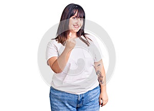 Young plus size woman wearing casual clothes beckoning come here gesture with hand inviting welcoming happy and smiling