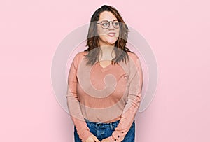 Young plus size woman wearing casual clothes and glasses smiling looking to the side and staring away thinking