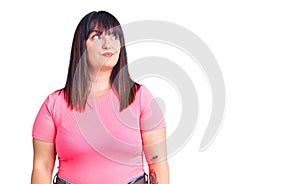 Young plus size woman wearing casual clothes smiling looking to the side and staring away thinking