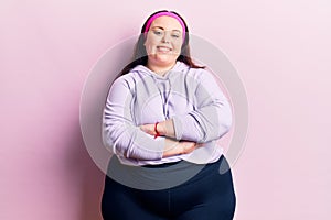 Young plus size woman wearing sportswear happy face smiling with crossed arms looking at the camera