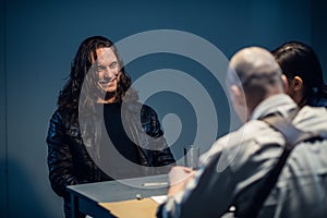 Young police officers are interrogating, the suspect laughs audaciously