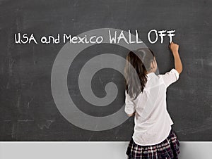 Young political activist schoolgirl writing on school classroom blackboard Mexico and USA wall off photo