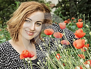 Young positive caucasian brunette and corn poppy flowers, beauty