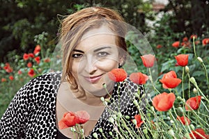 Young positive caucasian woman and corn poppy flowers, beauty an