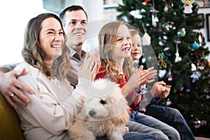 Young positive family enjoying Christmas evening at home