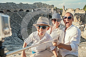 Young positive famly take a vacation photo on the Side ampitheatre view