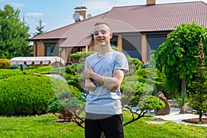 Young positive man with disability posing while standing outdoors