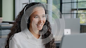 Young positive woman in headphones communicates via video call call center operator talks to customer on online