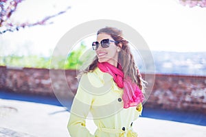 Young positive woman walking in park with toothy smile looking back