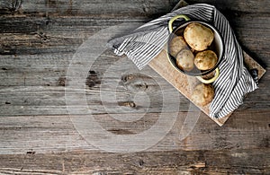 Young potatoes sitting on cutting board, topview