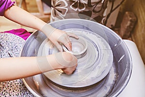 Young potter hands working with clay on pottery wheel