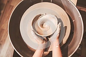 Young potter hands working with clay on pottery wheel