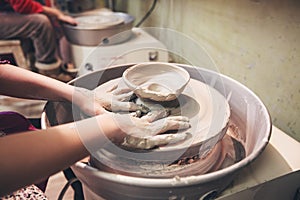 Young potter hands working with clay on pottery wheel