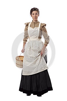 Young prairie woman with apron holding skirt and a basket isolated on white