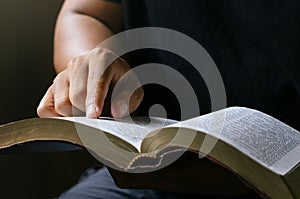 Young prayer sitting in chruch for reading bible and worship god, garden nature background. Bible concept
