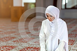 Young praying woman falling on knees in mosque