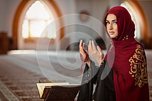Young praying woman falling on knees in mosque