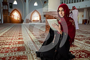 Young praying woman falling on knees in mosque