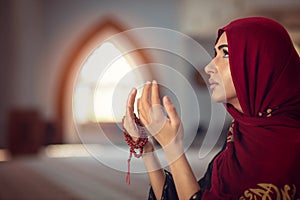 Young praying woman falling on knees in mosque