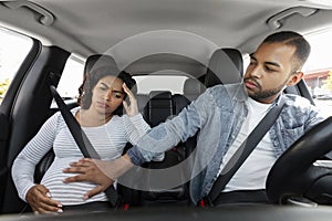 Young pregnant african american woman feeling pain in car