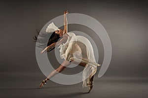 Young pregnant ballerina performing classical ballet pose