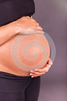 Young pregnant black woman touching her belly