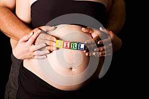 Young pregnant couple holding wood playing blocks