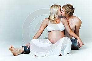 Young Pregnant Couple Kissing